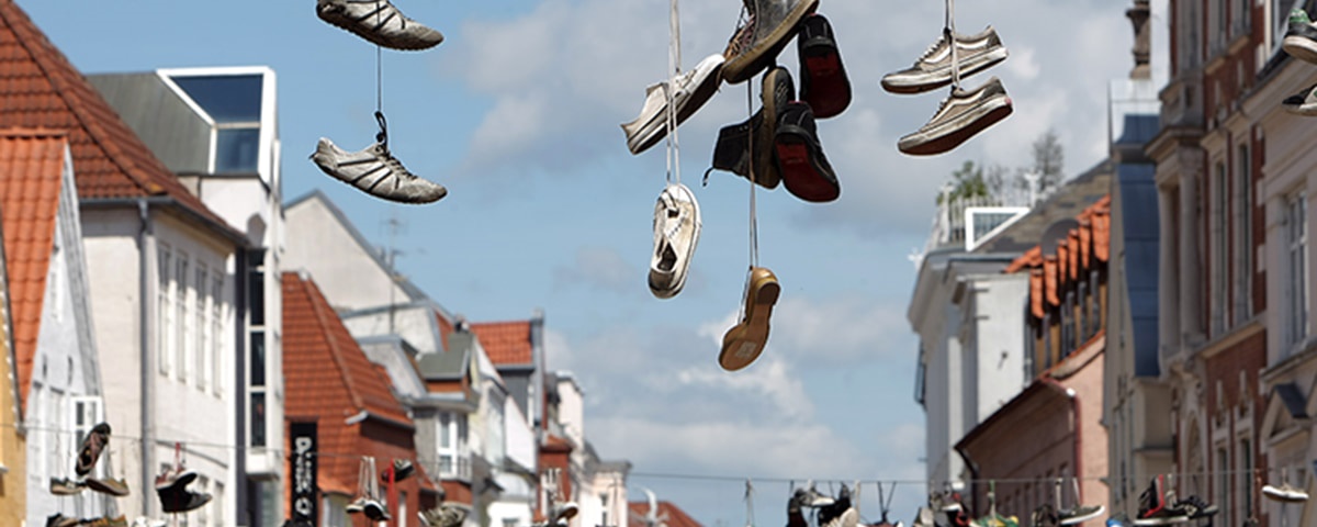 Schuhe hängen an den Schnürsenkeln über der Altstadt von Flensburg. 