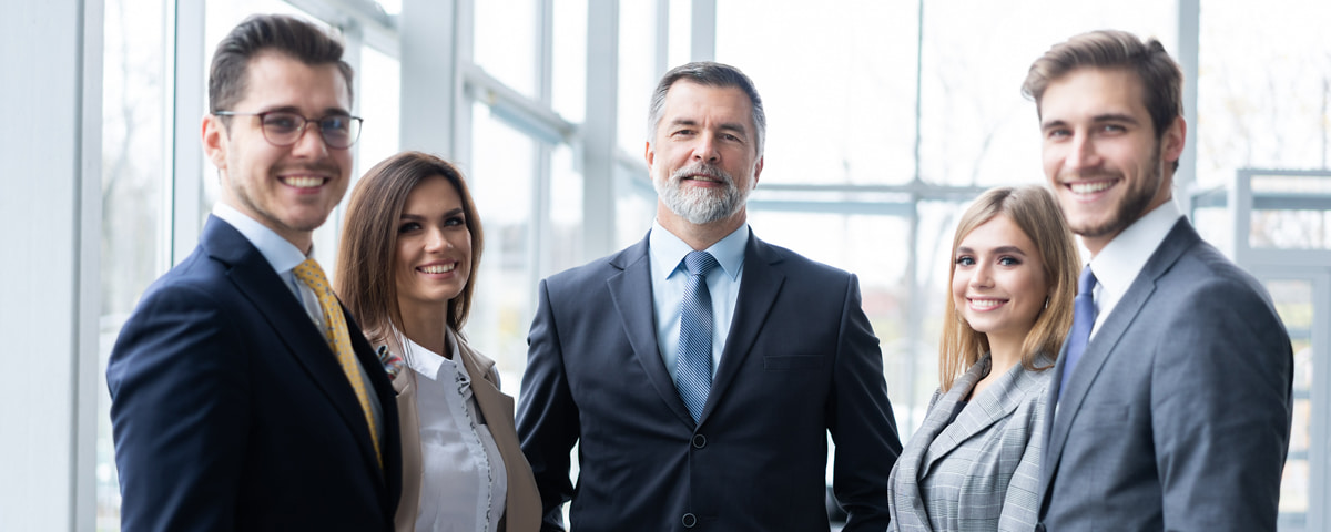 Fünf Mitarbeiter des Managements der Malteser lächeln gemeinsam in die Kamera.